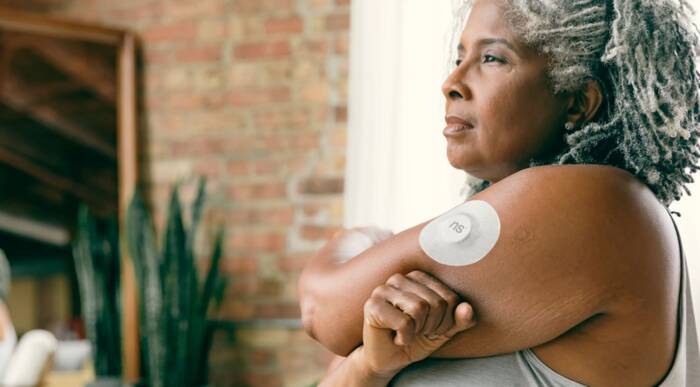 A client wearing a continuous glucose monitor on her arm